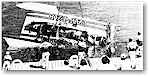 Crewmen watch as a crane lifts the damaged Pay 'n Pak out of the water.